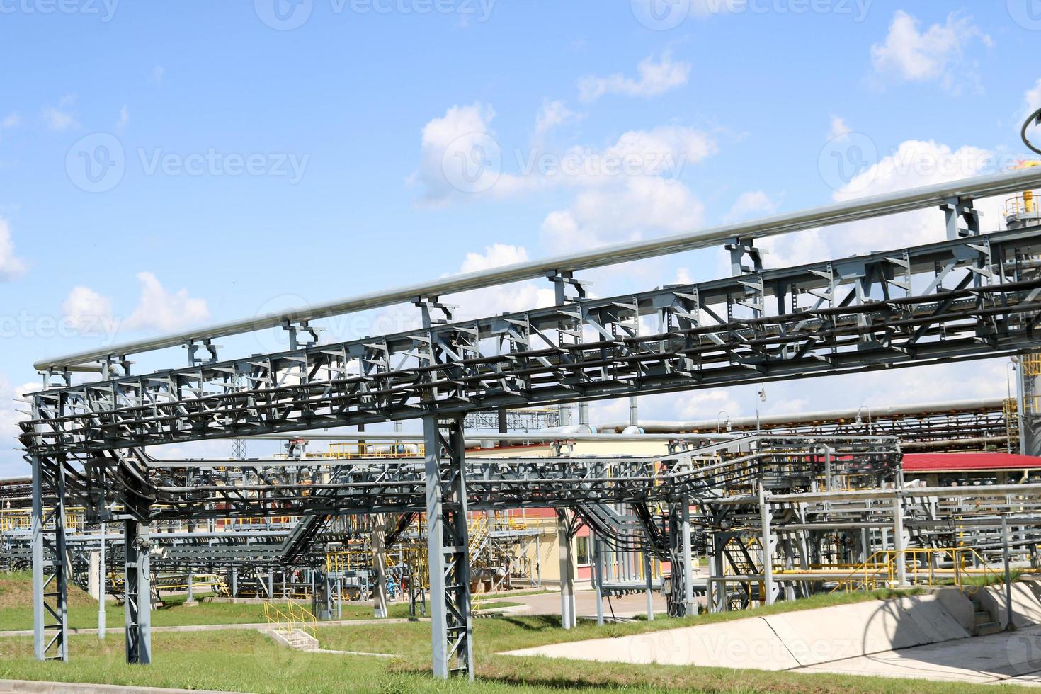 un' grande ferro metallo tubatura cavalletto con tubi e elettrico fili e attrezzatura a il prodotto petrochimico raffineria industriale raffineria foto