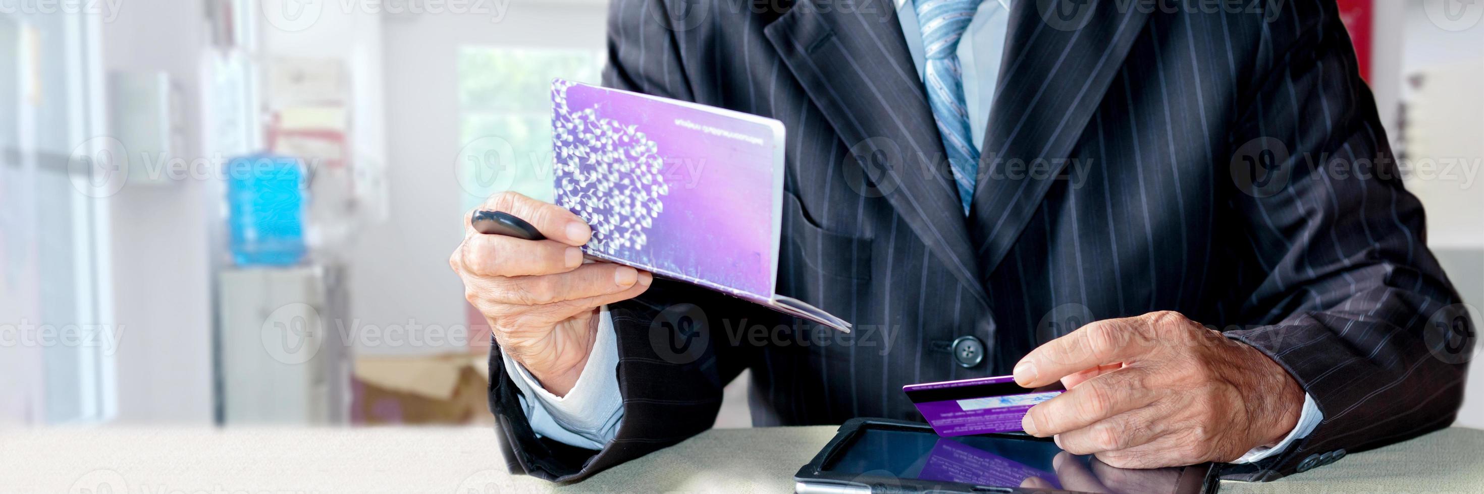 uomo d'affari mano Tenere un' plastica credito carta e banca libro foto