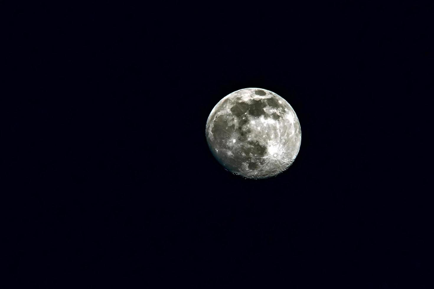 luna quasi piena sul cielo nero foto