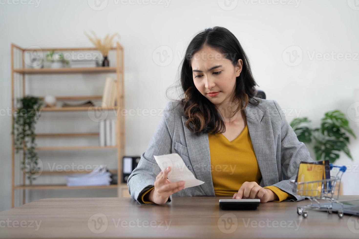 giovane asiatico donna calcolatore spese domestico di finanza e frustrato su scrivania a casa, ragazza controllo conto avendo fatica e preoccupato, debito e imposta, espressione e emozione, attività commerciale concetto. foto