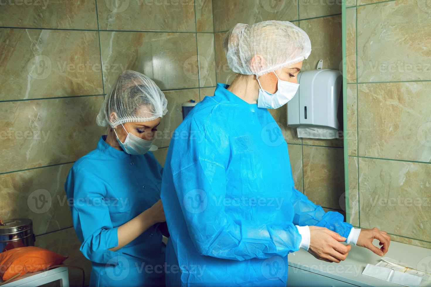 adulto donna medico preparazione per il operazione con un assistente foto