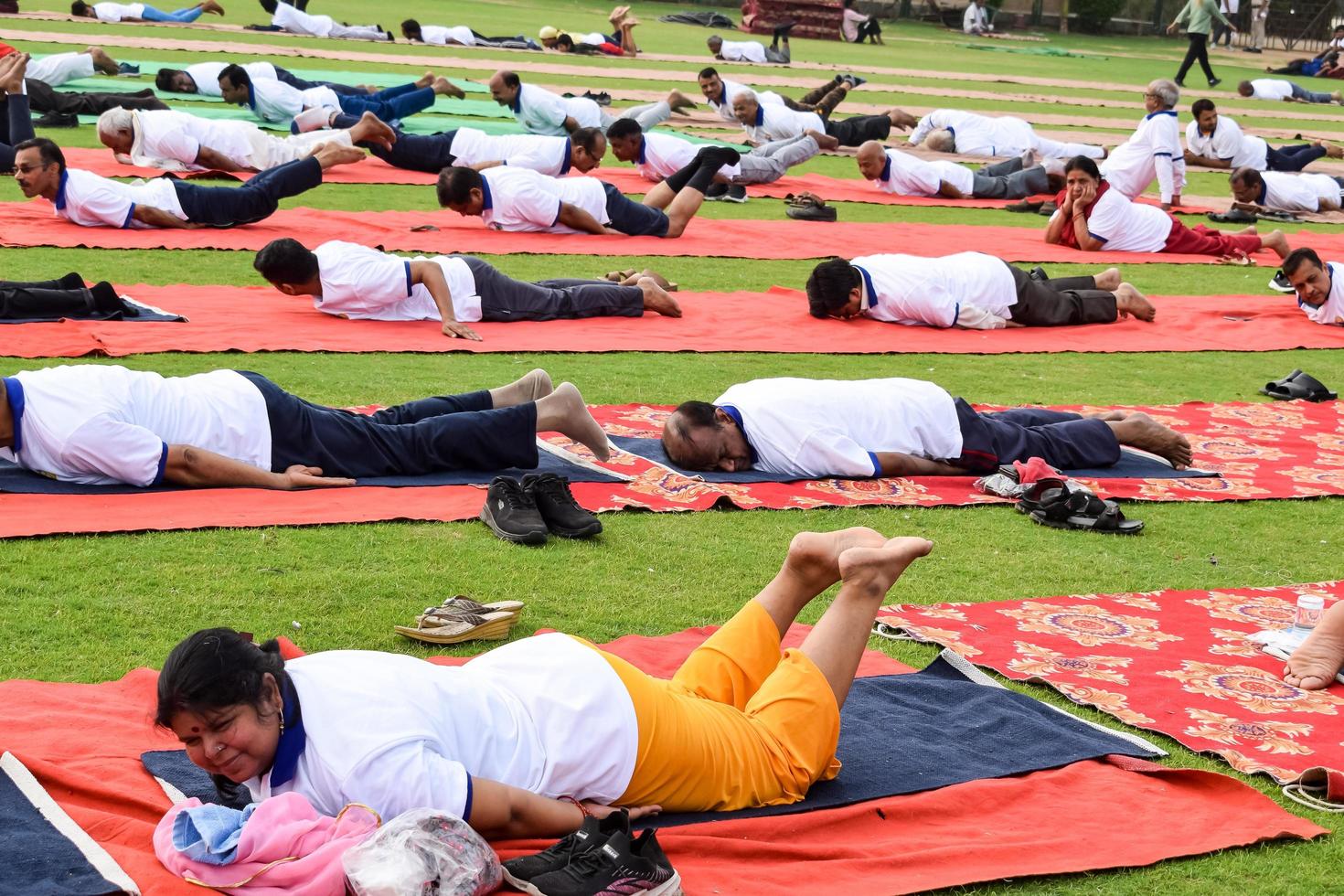 nuovo delhi, India, giugno 21 2022 - gruppo yoga esercizio sessione per persone a yamuna gli sport complesso nel delhi su internazionale yoga giorno, grande gruppo di adulti frequentando yoga classe nel cricket stadio foto