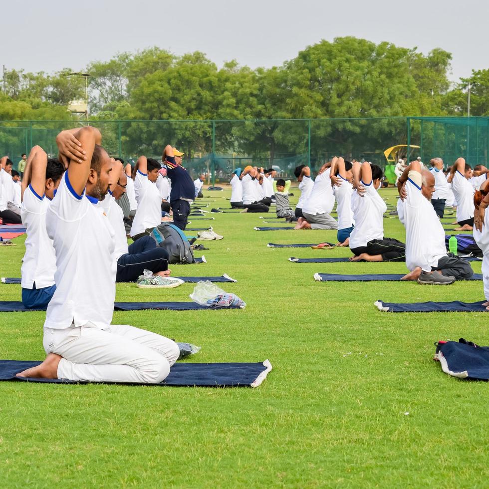 nuovo delhi, India, giugno 21 2022 - gruppo yoga esercizio sessione per persone a yamuna gli sport complesso nel delhi su internazionale yoga giorno, grande gruppo di adulti frequentando yoga classe nel cricket stadio foto