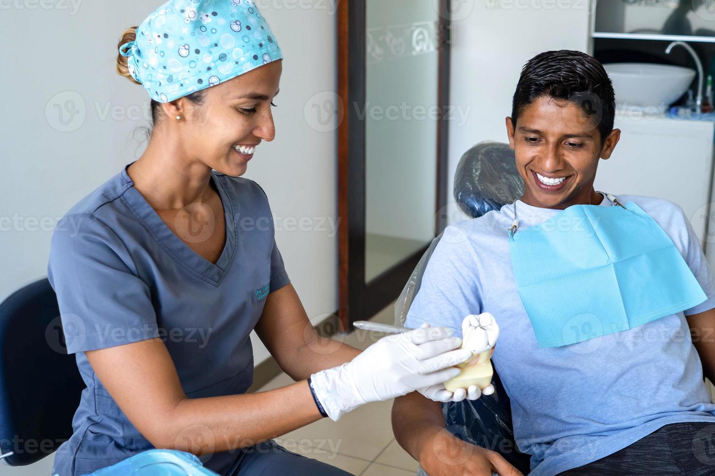 giovane dentista spiegando per un' paziente nel il dentale studio. foto