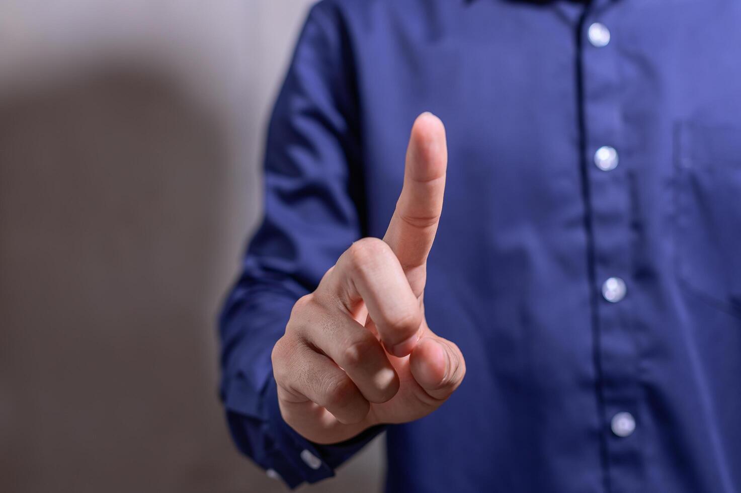 uomo d'affari che punta il dito in una camicia blu foto