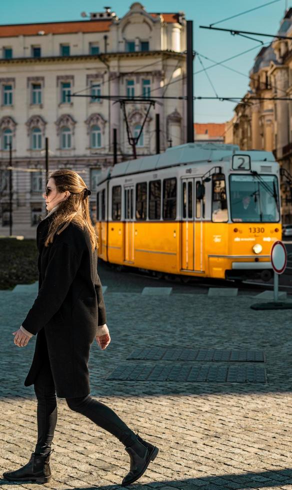 budapest, ungheria, 2020 - donna che cammina davanti a un tram foto