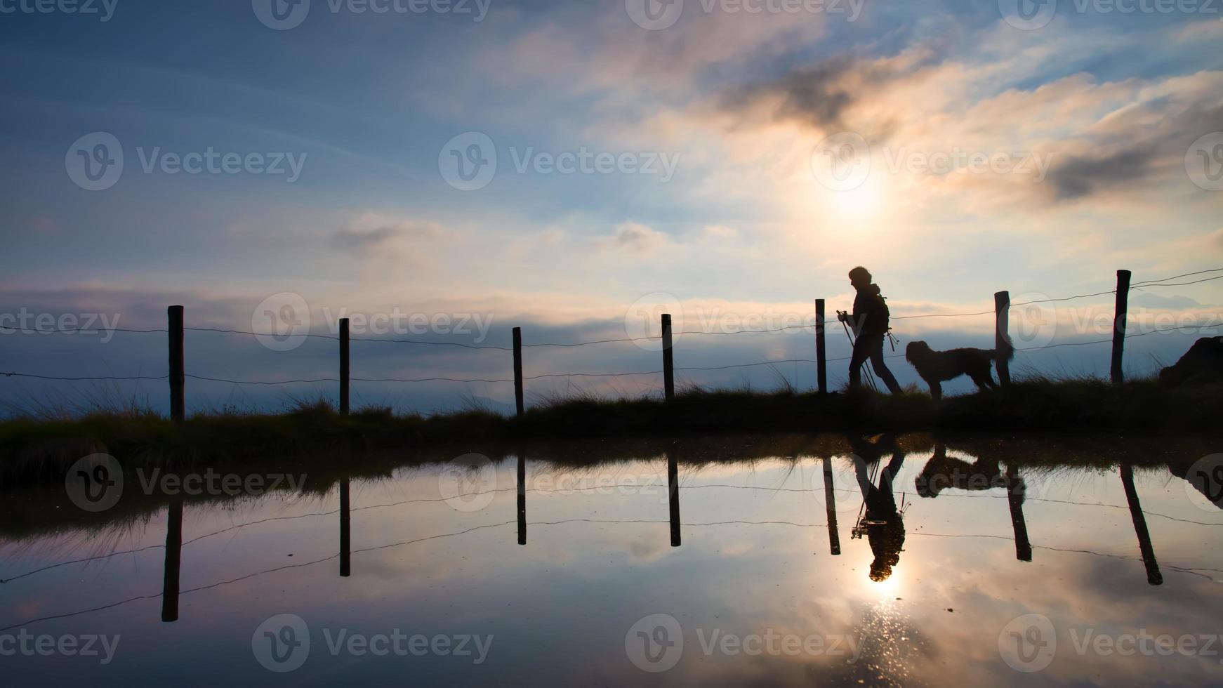 un' donna su un' montagna escursione con sua Amati cane a tramonto foto