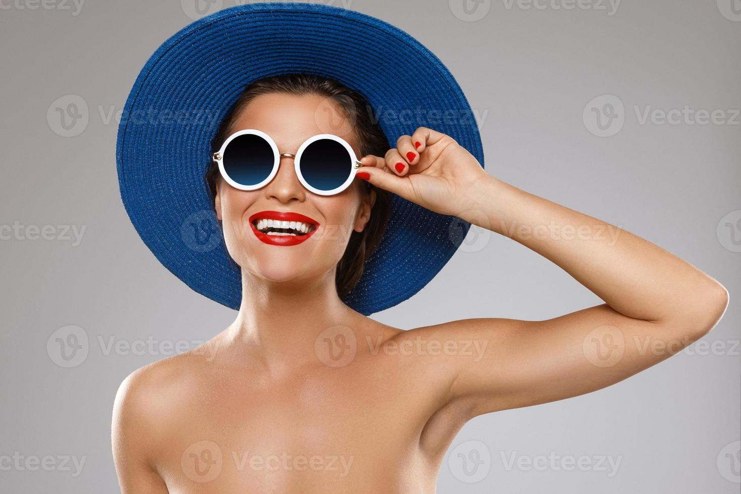 bellissimo donna indossare blu cappello e occhiali da sole è pronto per vacanza foto