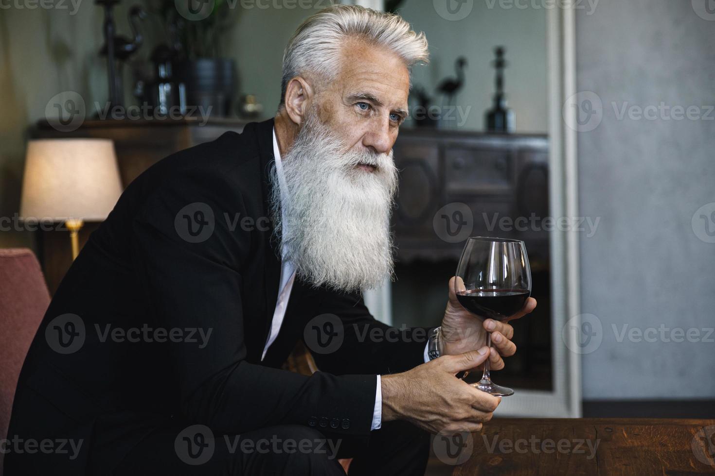 bello barbuto anziano uomo potabile rosso vino foto