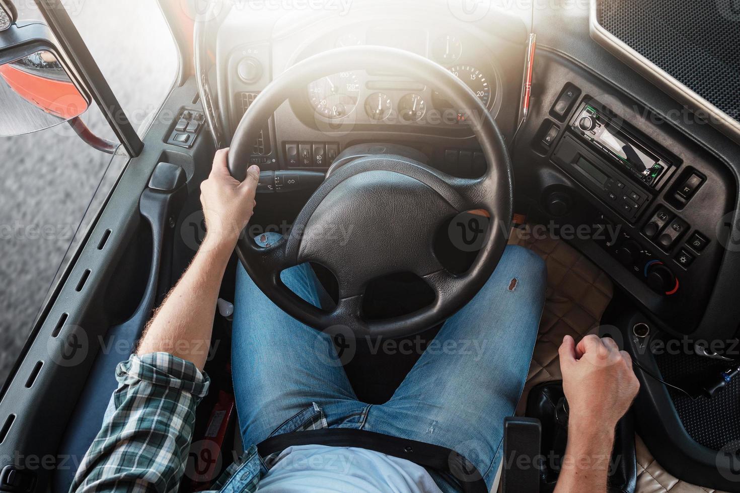 maschio camion autista guida il suo grande veicolo. timone ruota e pannello di controllo di camion. foto