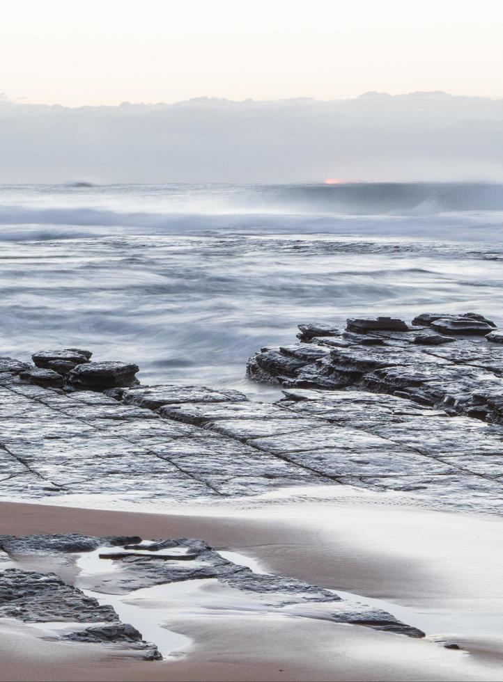 lunga esposizione delle onde su una spiaggia foto