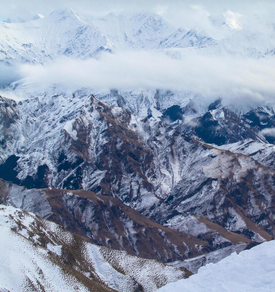 vista a volo d'uccello di montagne marroni coperte di neve foto