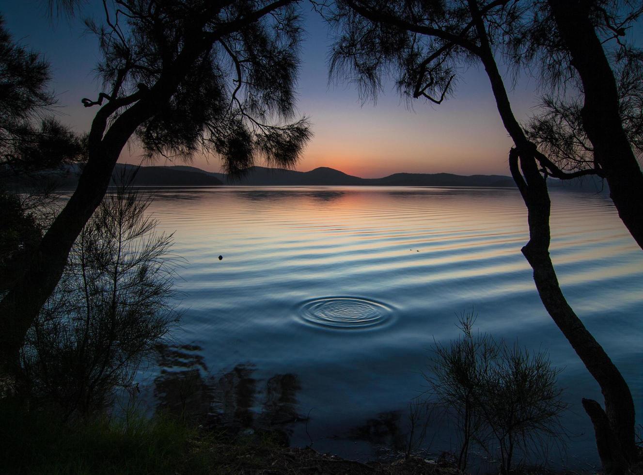 calmo specchio d'acqua al tramonto foto