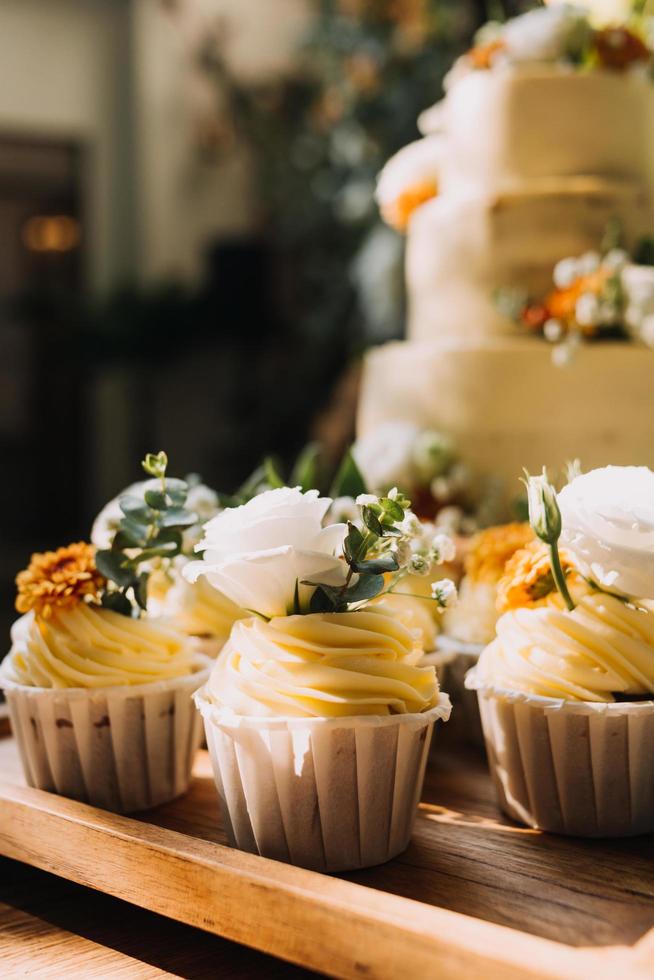 buongustaio cupcakes con bianca buttercream glassa e spruzzatori su di legno sfondo foto