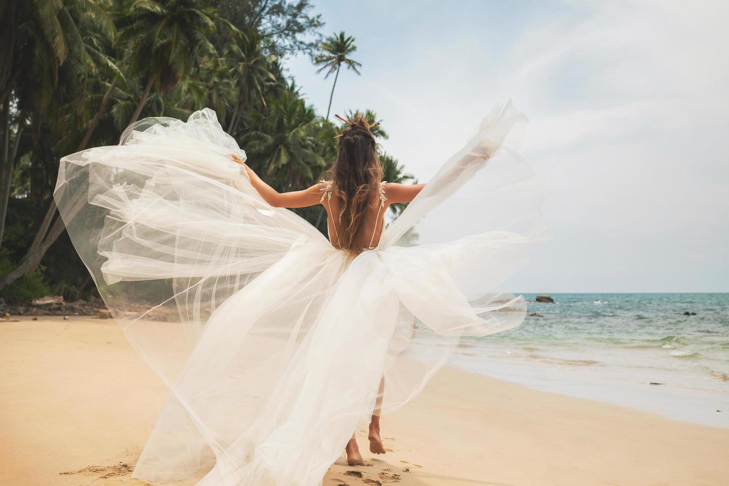 sposa indossare bellissimo nozze vestito su il tropicale spiaggia foto