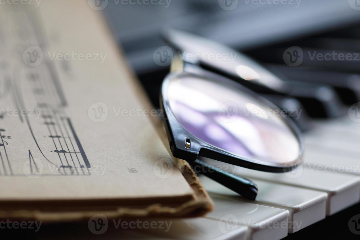 foglio musica e occhiali su il pianoforte chiavi foto