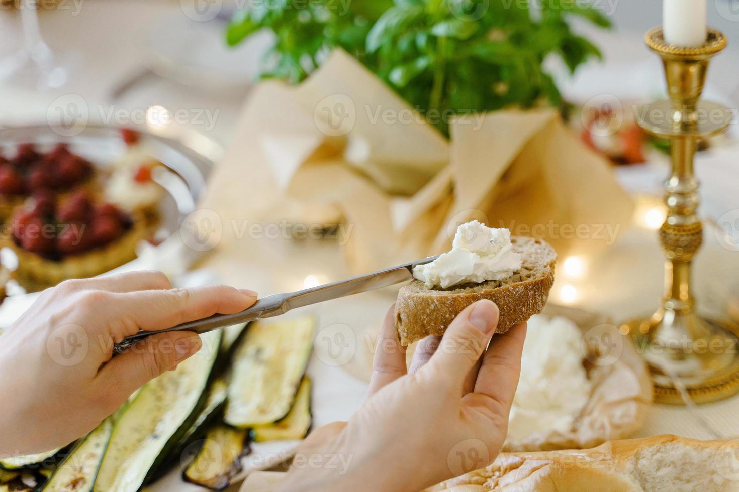donna fabbricazione un' Sandwich a il festivo tavolo. foto