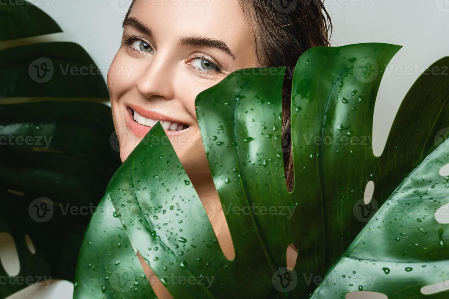 giovane donna con un' liscio pelle Tenere Monstera deliciosa pianta foglia foto