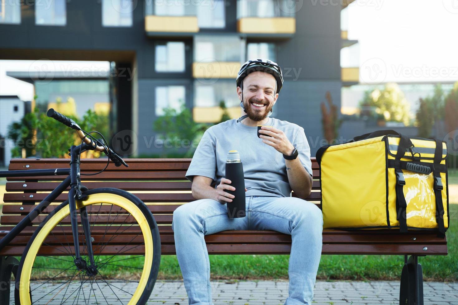 esprimere consegna Corriere seduta su panchina e potabile caffè. foto