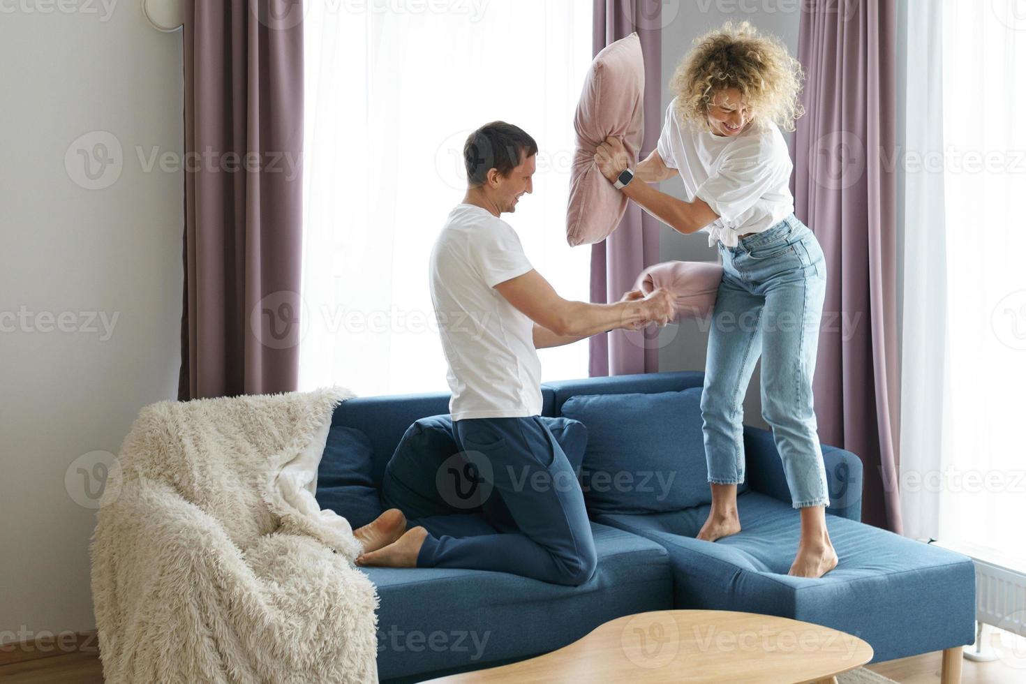 contento coppia durante cuscino combattimento nel loro appartamento foto