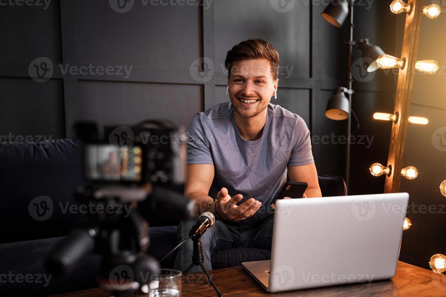 giovane sorridente blogger è seduta nel davanti di un' il computer portatile foto