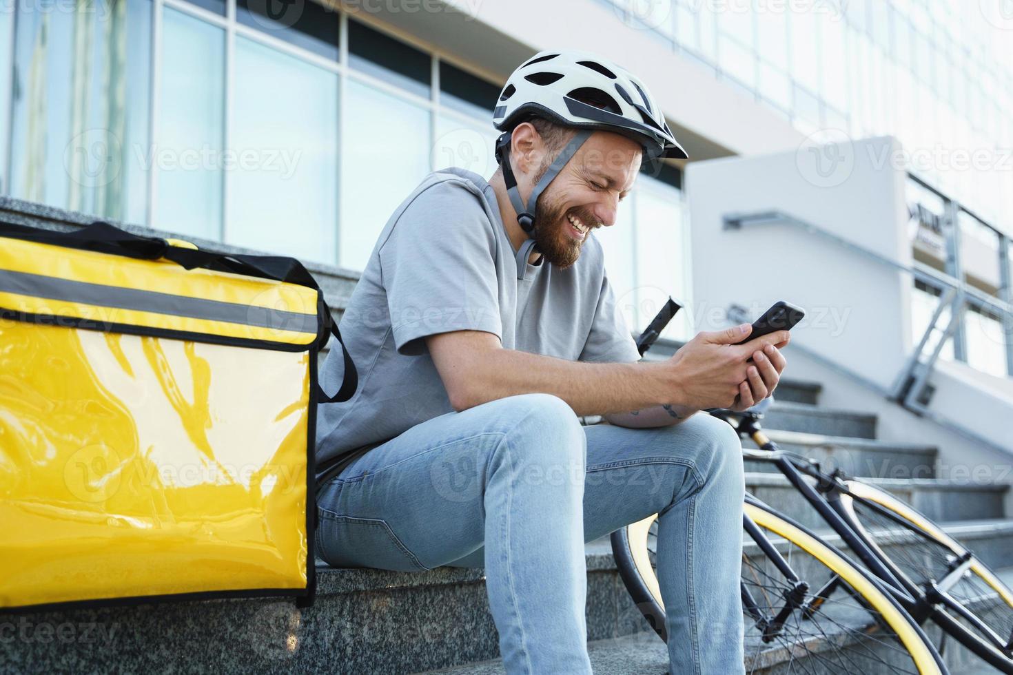 esprimere cibo consegna Corriere seduta su il le scale con isolato Borsa e bicicletta. foto