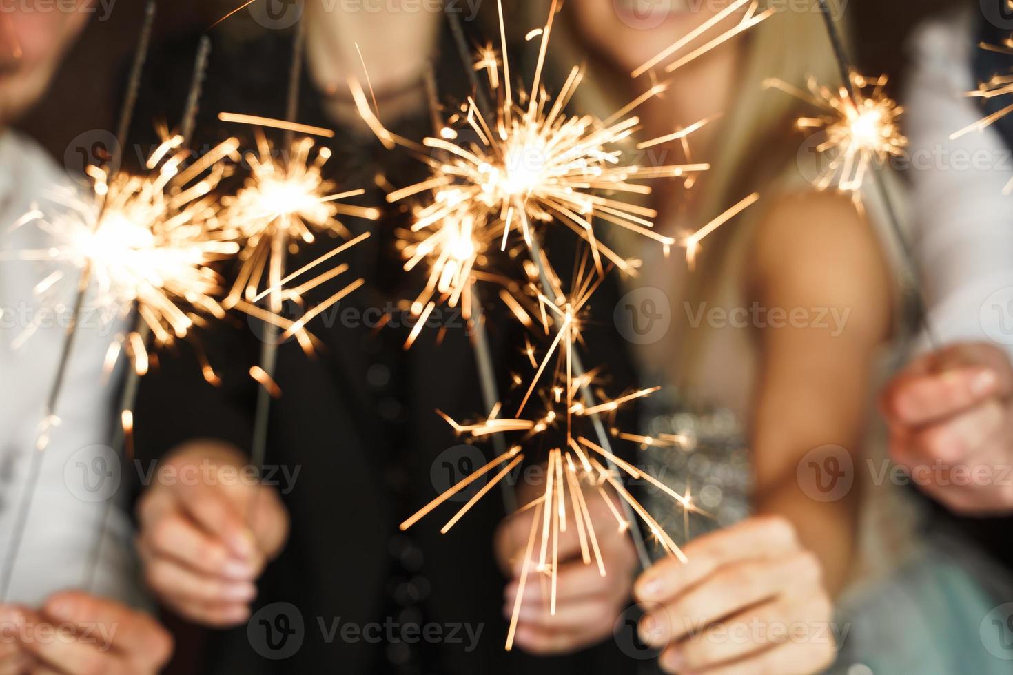 su di focalizzata Immagine di persone con sparklers festeggiare vacanza o evento foto