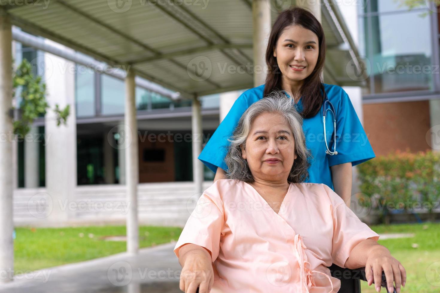 caregiver asiatico attento o infermiere che si prende cura del paziente su una sedia a rotelle. concetto di felice pensionamento con la cura di un caregiver e risparmi e assicurazione sanitaria senior, una famiglia felice foto