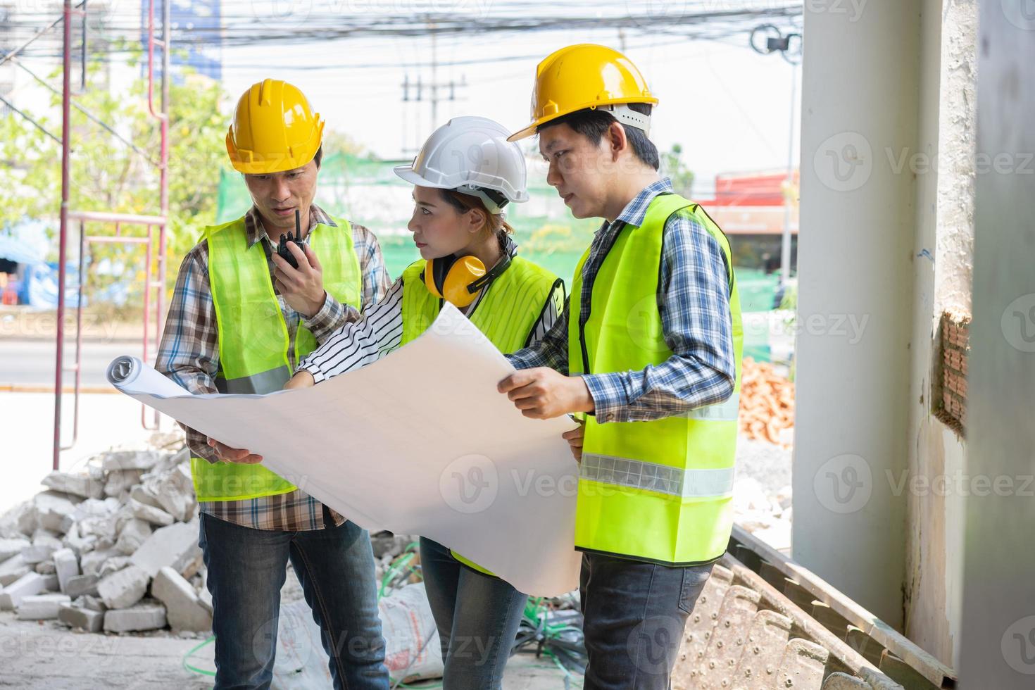 ingegnere asiatico o giovane architetto donna indossa un casco per la sicurezza e parla con un appaltatore su un progetto di fabbrica edile, concetto di lavoro di squadra, concetto di leadership. foto