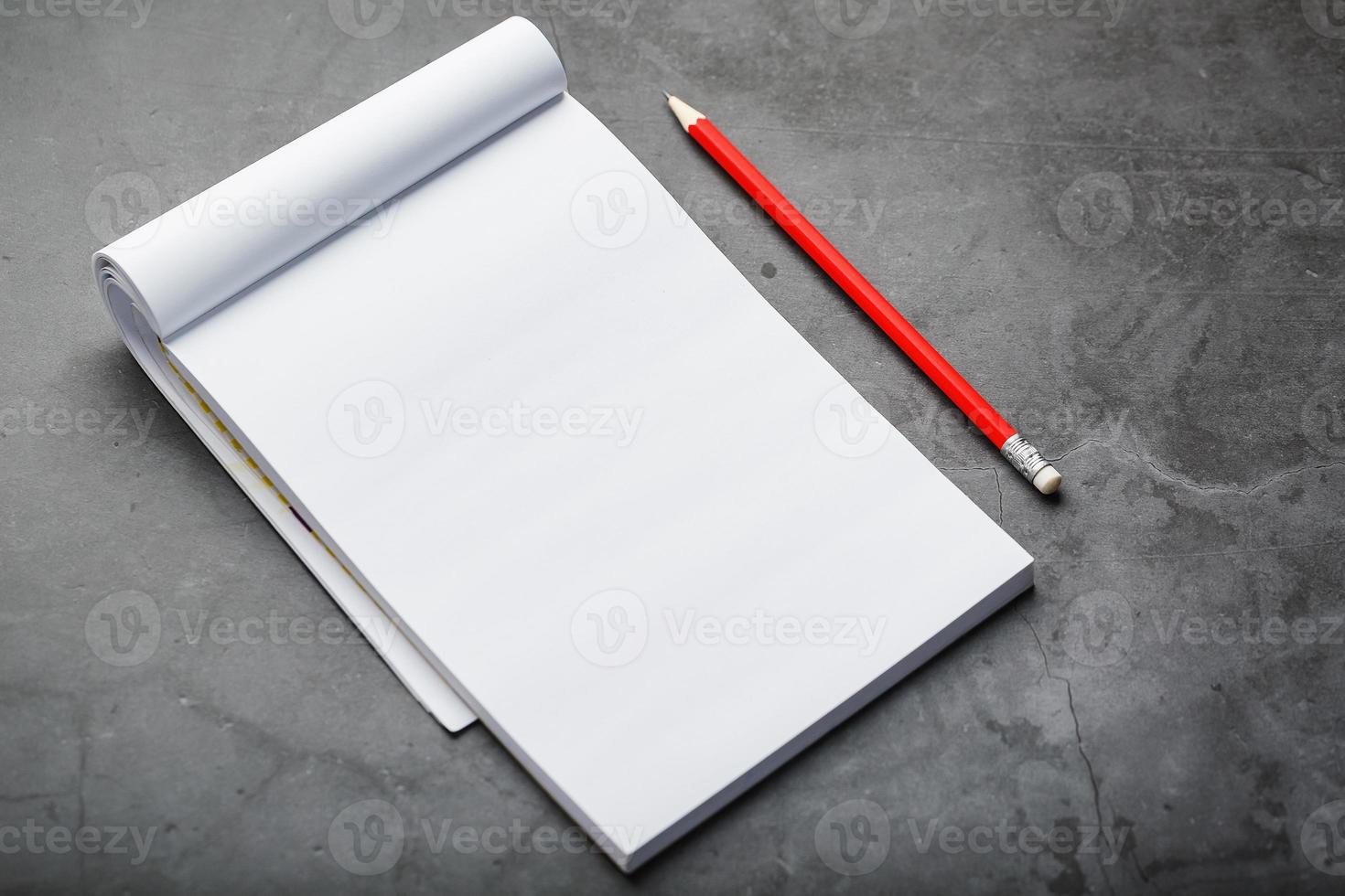 bloc notes con un' rosso matita su un' nero pietra piatto sfondo, per formazione scolastica, registrazione obiettivi e fatti foto