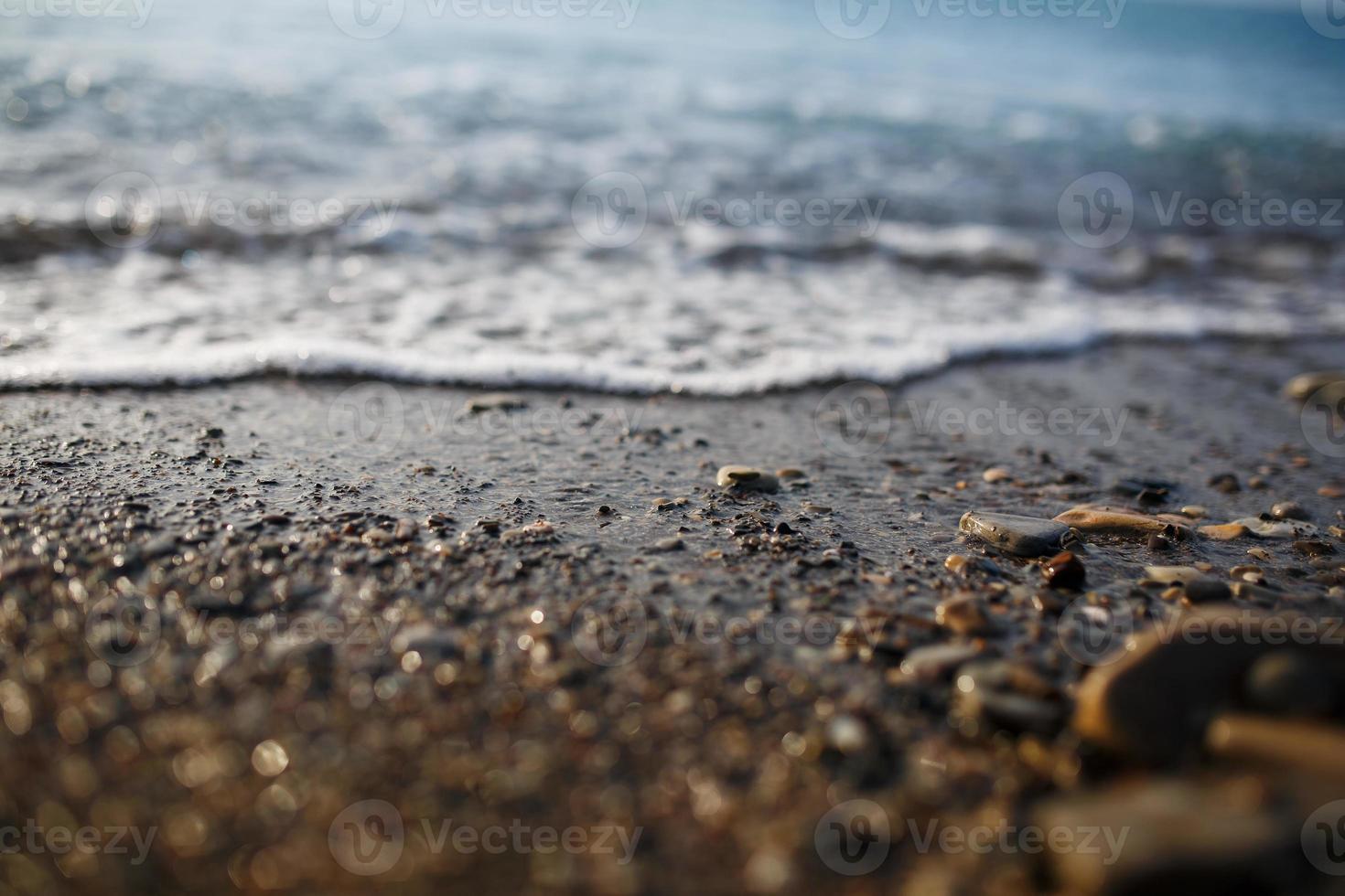 mare onde di il blu mare con schiuma rotolo a terra il d'oro costa. avvicinamento foto