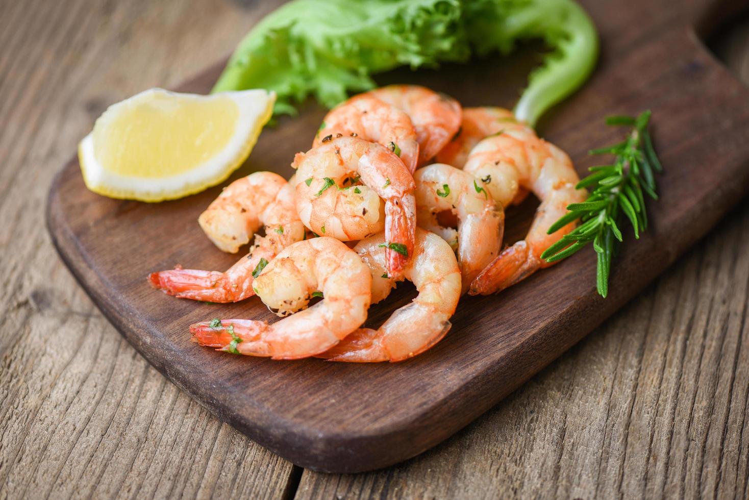 insalata gamberetto grigliato delizioso stagionatura spezie su di legno taglio tavola sfondo appetitoso cucinato gamberetti al forno gamberi , frutti di mare scaffale con rosmarino Limone e lattuga foto