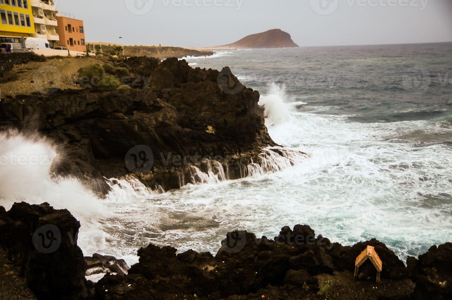 onde spruzzi su roccioso riva foto