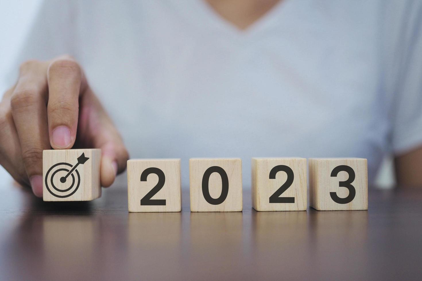 2023 nuovo anno obiettivi, piani, idee, ispirazione concetto. uomo d'affari Tenere un' di legno bloccare con 2023 obbiettivo simbolo, 2023 concetto. foto