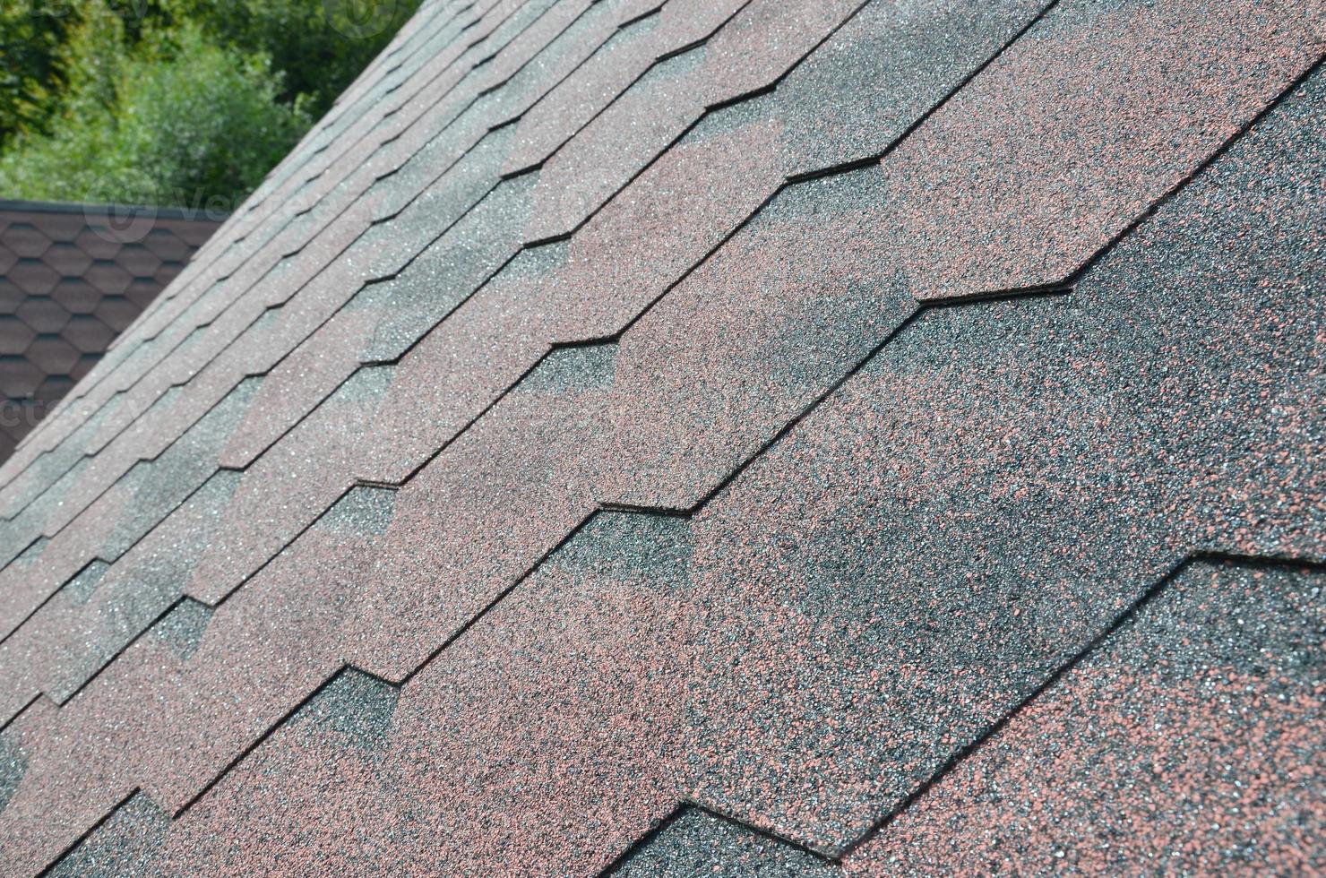 il struttura di il tetto con bituminoso Rivestimento. ruvido bituminoso mosaico di rosso e Marrone fiori. impermeabile coperture foto