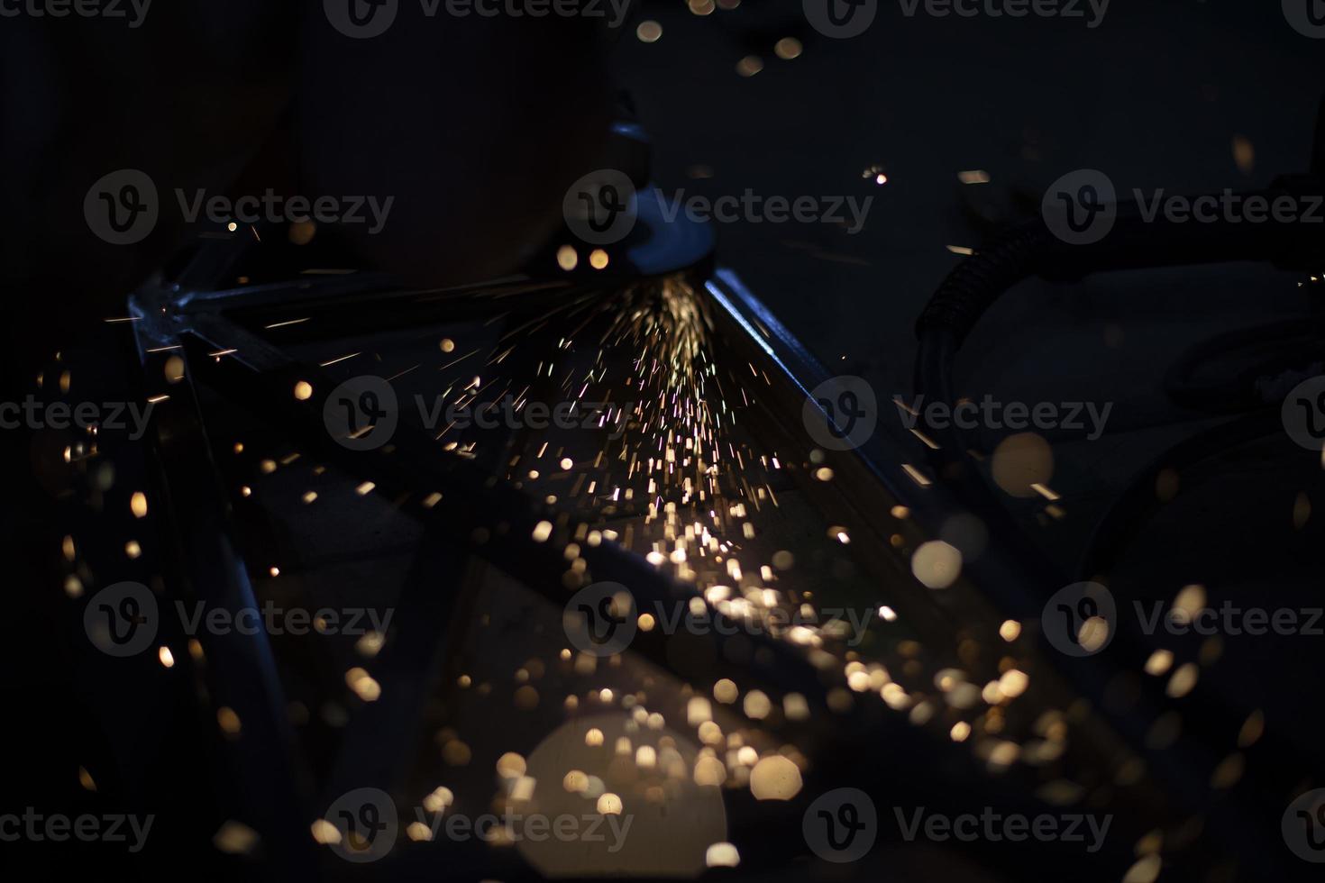 scintille nel scuro. metallo macinazione luci. dettagli di le smerigliatrici opera. foto