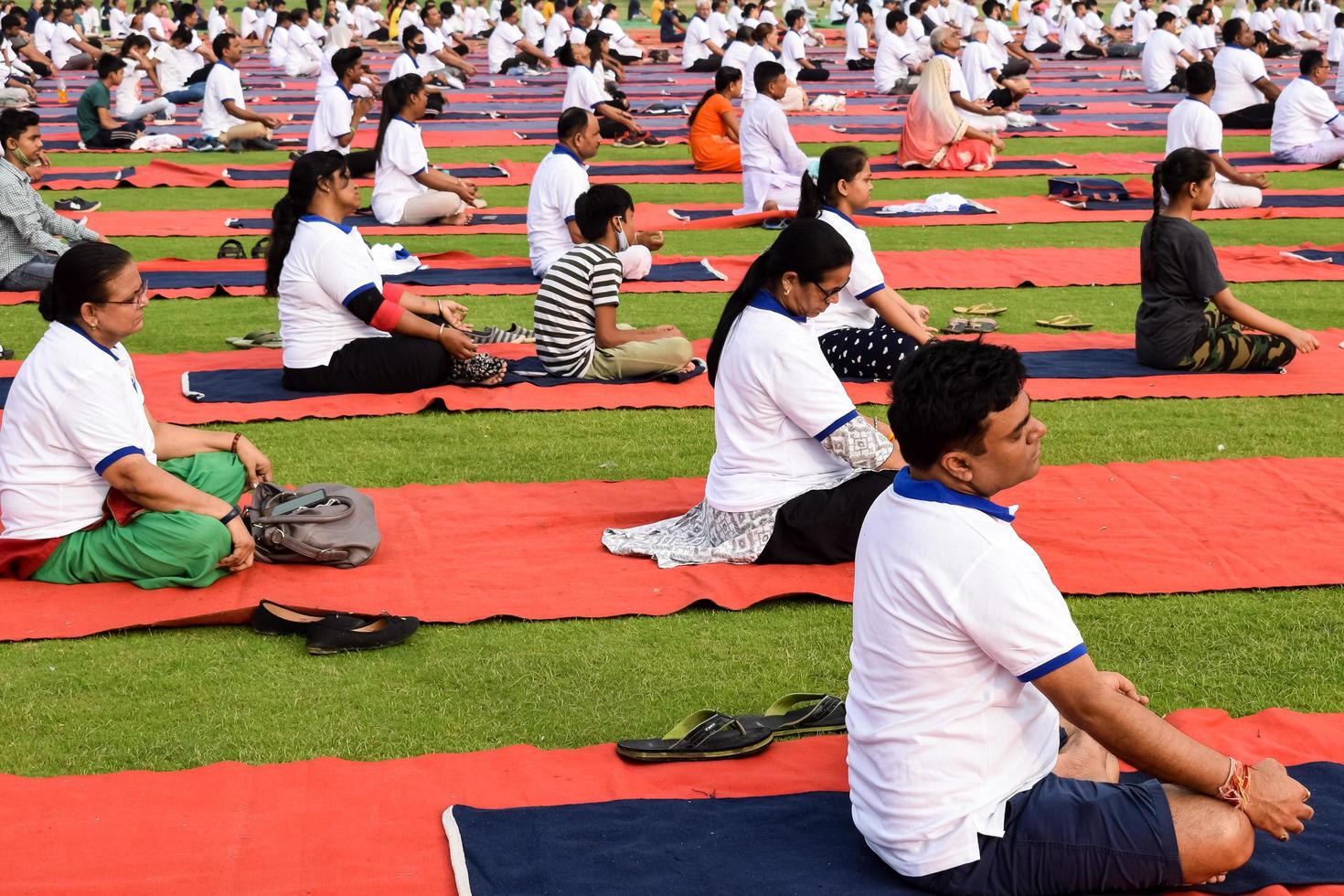 nuovo delhi, India, giugno 21 2022 - gruppo yoga esercizio sessione per persone a yamuna gli sport complesso nel delhi su internazionale yoga giorno, grande gruppo di adulti frequentando yoga classe nel cricket stadio foto