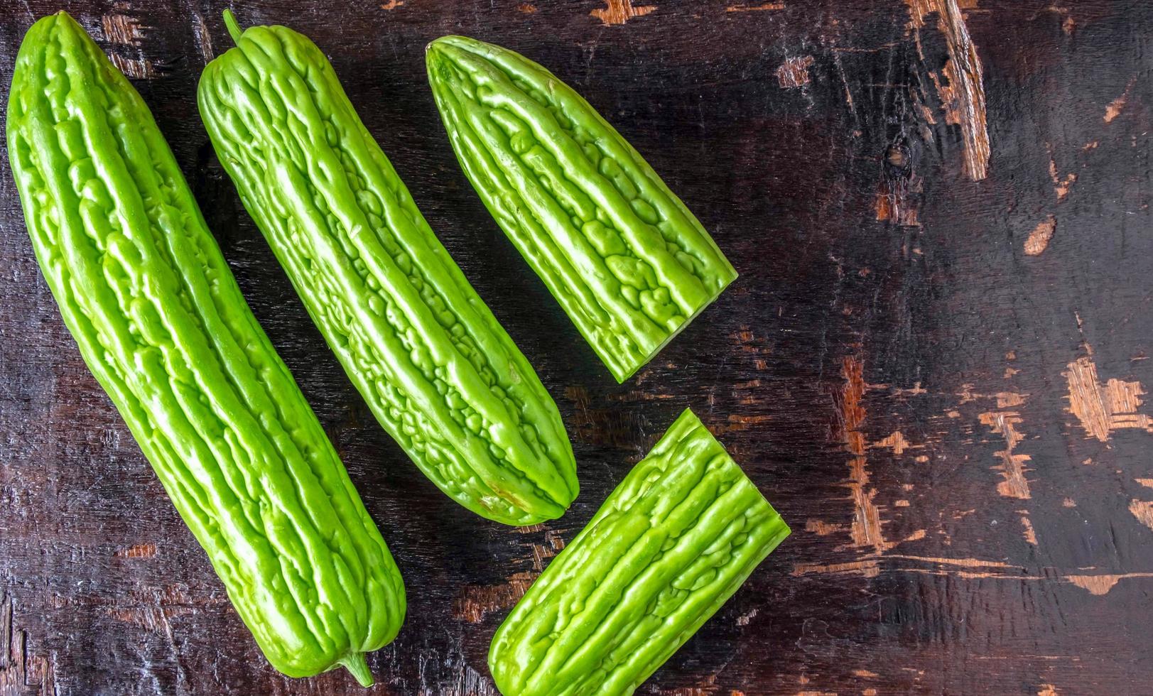 superiore Visualizza di fresco verde amaro melone o amaro zucca verdura nel un' cestino posto su un vecchio di legno sfondo foto