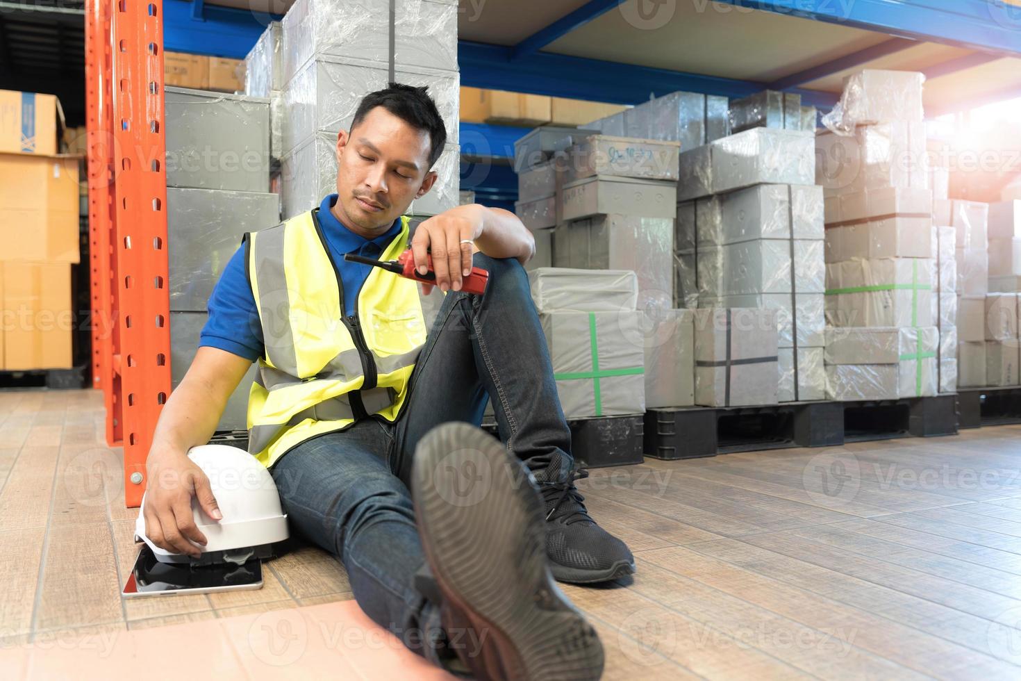 logistica lavoratore uomo fatica sedersi nel magazzini preoccupato, esausto a partire dal lavorare troppo e a buon mercato salari come il finanziario crisi entra un economico recessione. foto