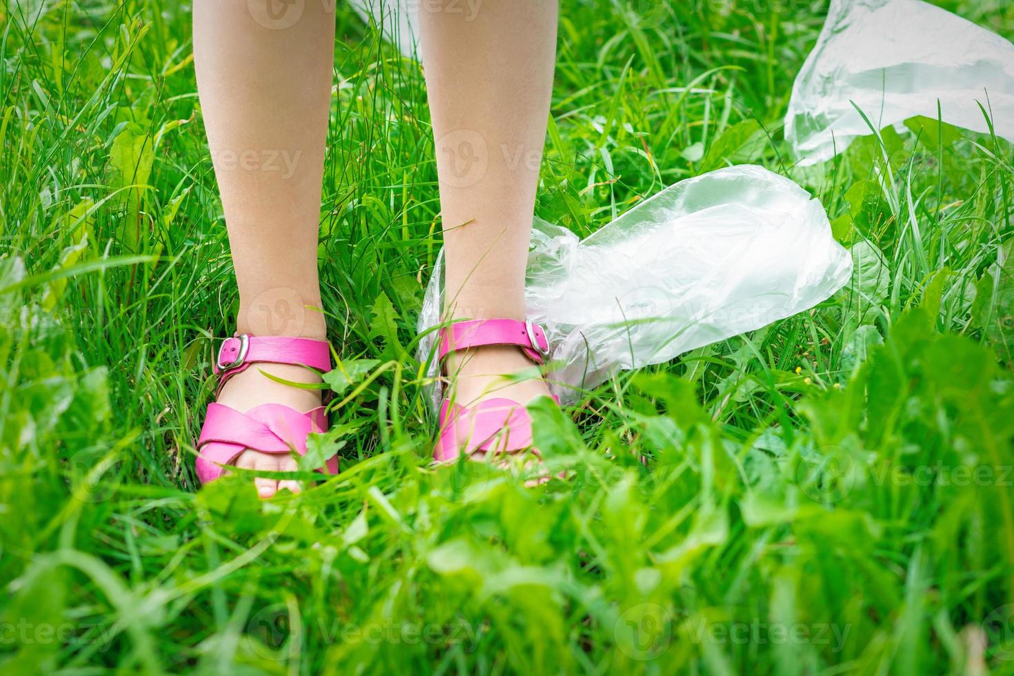 plastica borse spazzatura con figli di piedi su verde erba foto