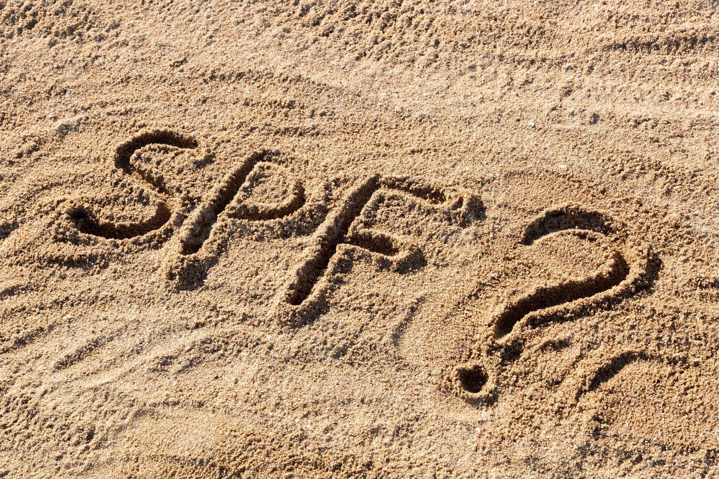 sole proteggere fattore concetto. spf parola scritto su il spiaggia con domanda marchio foto