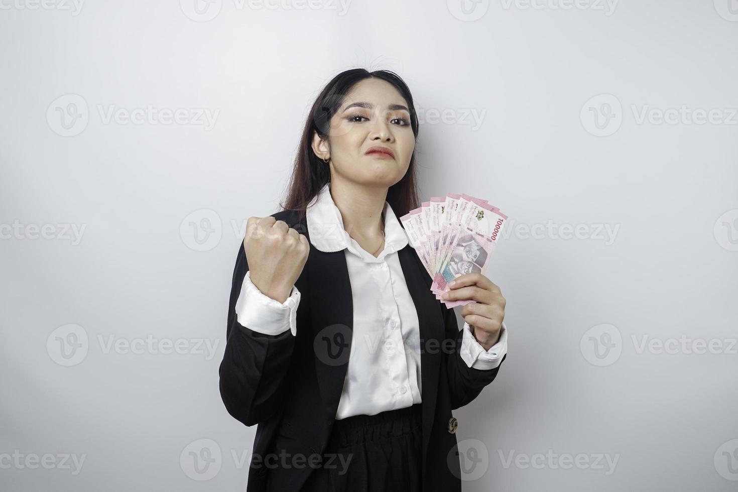 un' ritratto Se un' giovane donna d'affari con un' pila di i soldi nel indonesiano rupia nel sua mani isolato di bianca sfondo foto