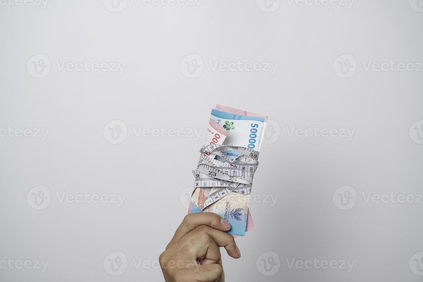 indonesiano rupia siamo legato con un' misurazione nastro. i soldi misurazione concetto. il dimensione di finanziario investimenti, il quantità di reddito. foto