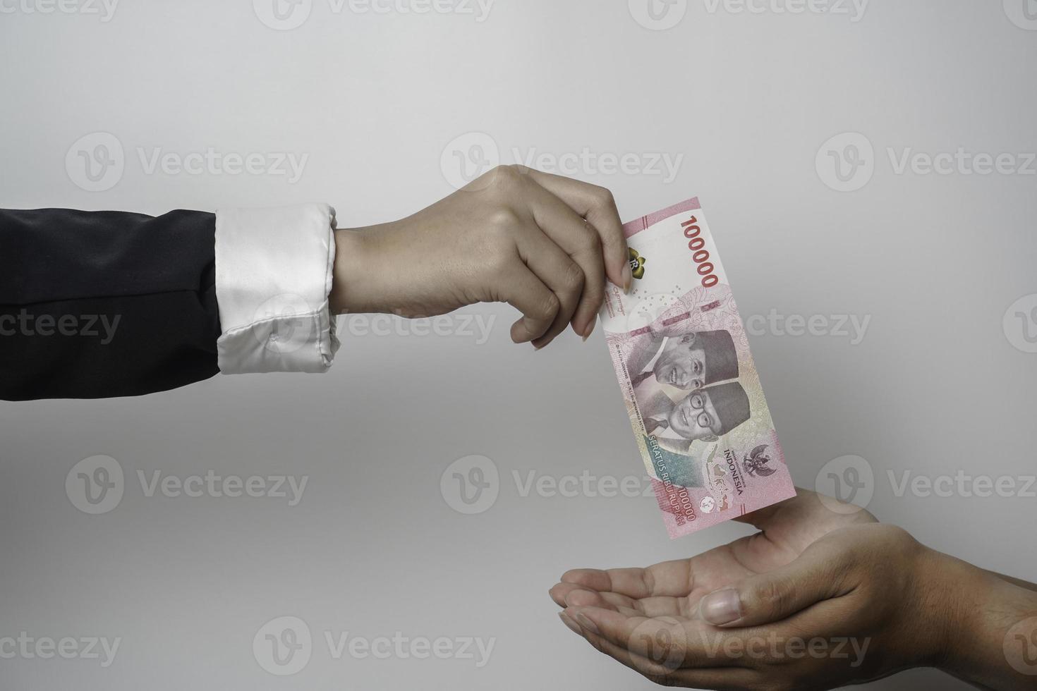 un' ritratto di uomo d'affari dando i soldi nel indonesiano rupia per attività commerciale affare o pagamento o beneficenza foto