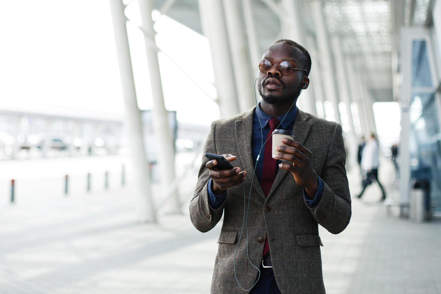 uomo d'affari afroamericano ascolta la musica nel suo smartphone foto