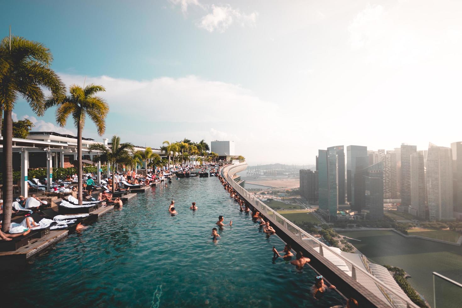 singapore, 2018: i viaggiatori nuotano al marina bay sands hotel foto