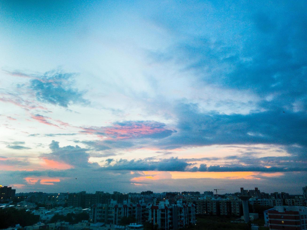 nuvole colorate sopra una città al tramonto foto