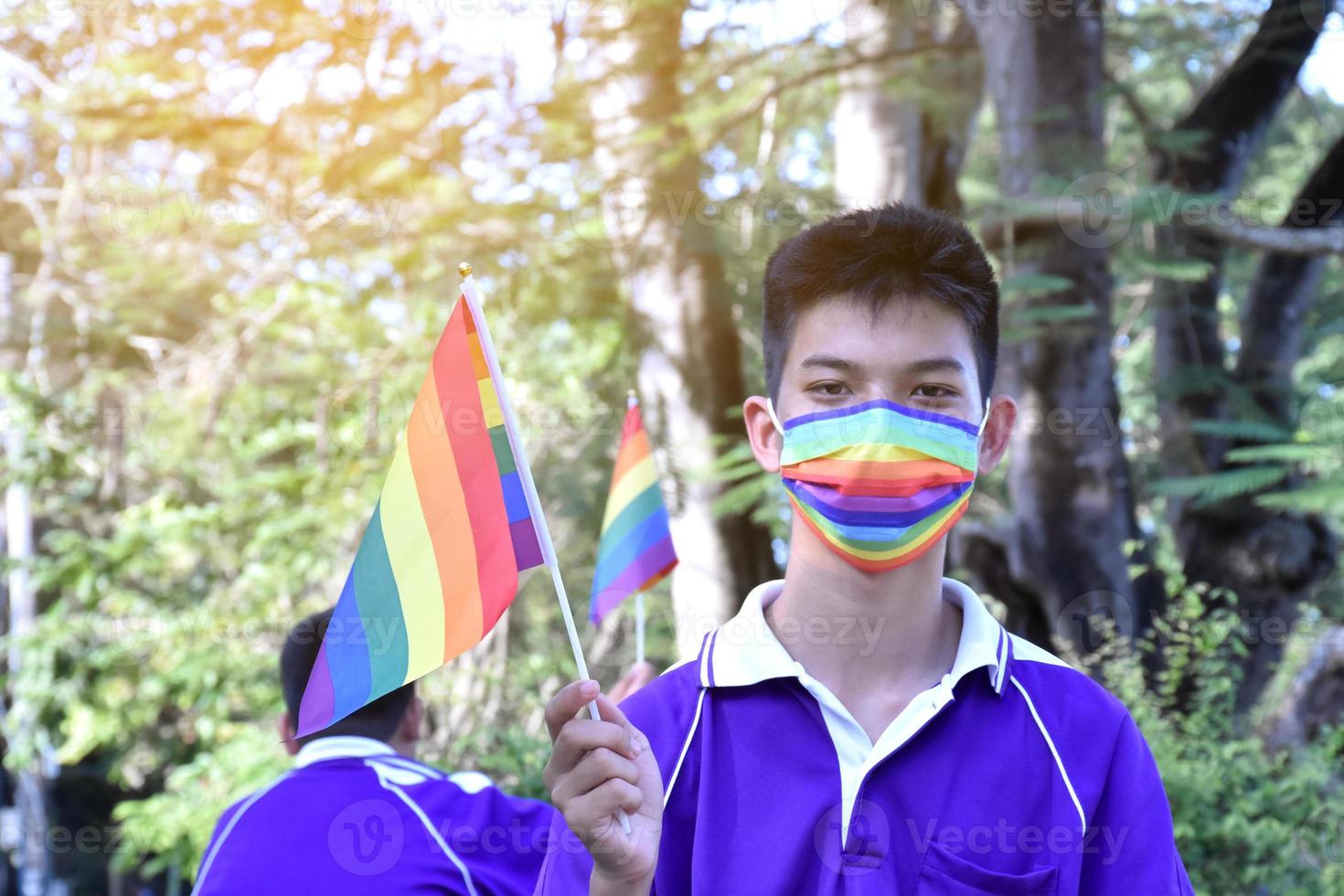 ritratto asiatico giovane ragazzo detiene arcobaleno bandiera, lgbt simbolo, nel mani mentre unendo il suo lgbt attività a scuola, concetto per lgbt Comunità celebrazione nel orgoglio mese, giugno, 2023, in giro il mondo. foto