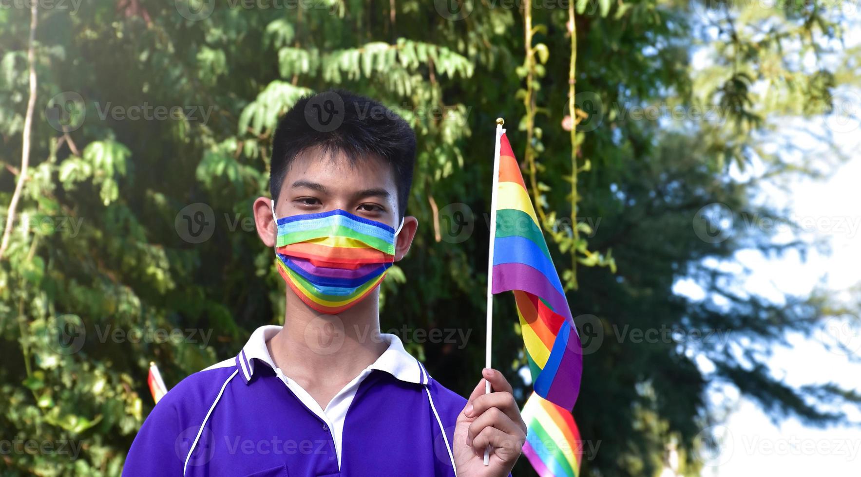 ritratto asiatico giovane ragazzo detiene arcobaleno bandiera, lgbt simbolo, nel mani mentre unendo il suo lgbt attività a scuola, concetto per lgbt Comunità celebrazione nel orgoglio mese, giugno, 2023, in giro il mondo. foto