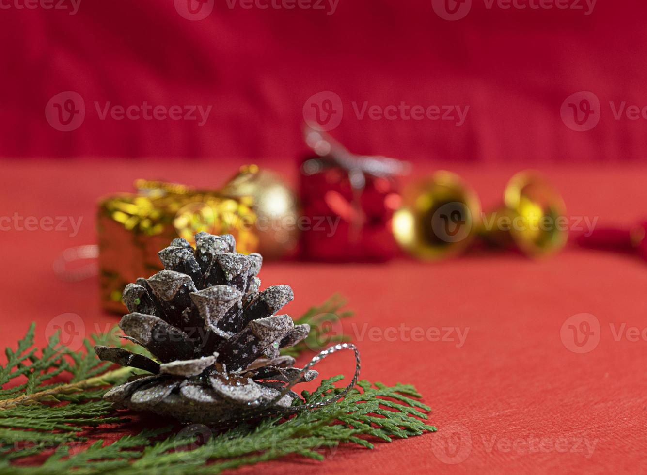 Natale composizione. Natale rosso decorazioni, abete albero rami su rosso sfondo con pino coni decorazioni. foto